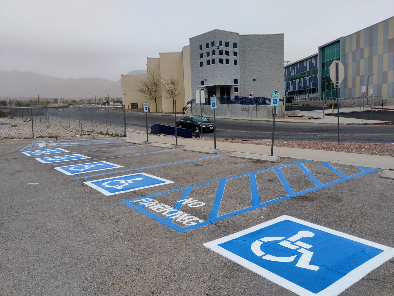 Fresh blue ADA stalls, stencils, and crosshatch striping on a commercial lot